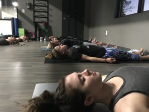 attendees of a spiritual workshop laying on their yoga mats